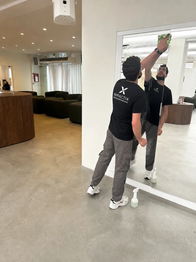 Mitarbeiter von IMPACTIX bei der Glasreinigung im Empfangsbereich